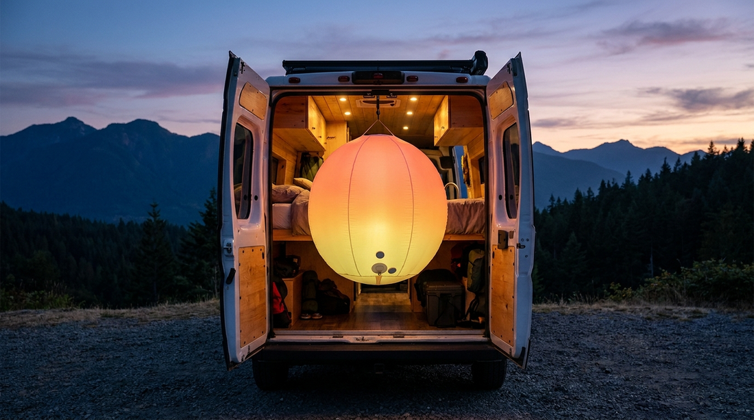 AirGlow-style spherical inflatable camp light glowing inside an open camper van at dusk